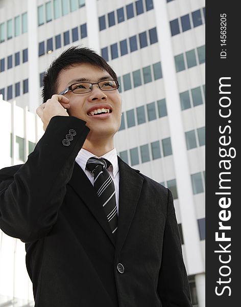 A young Asian businessman speaking on the phone