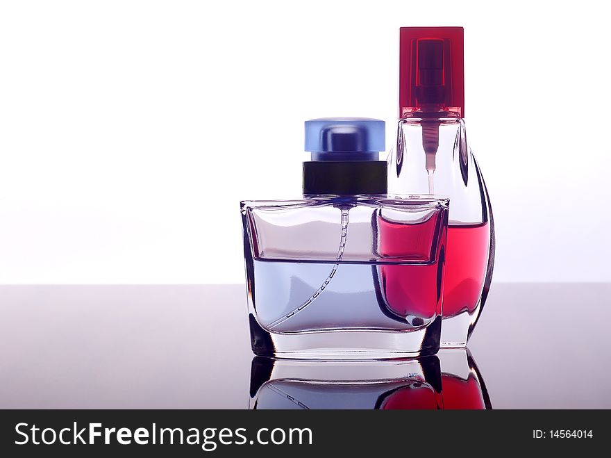 Two bottles with perfume on a glass surface. Two bottles with perfume on a glass surface