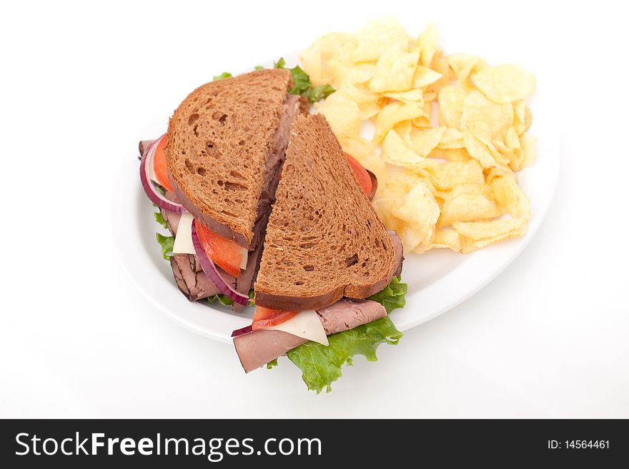 Delicious roast beef sandwich platter with whole wheat bread and potato chips. Delicious roast beef sandwich platter with whole wheat bread and potato chips