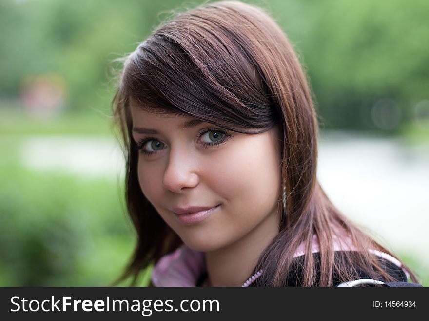 Portrait of the girl outdoors on the green bokeh  background in summer
