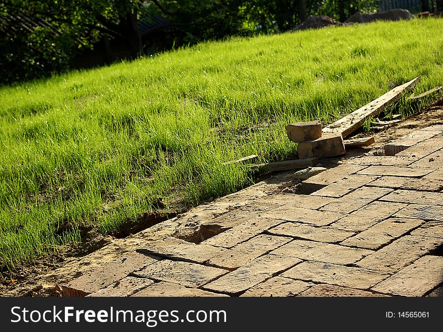 Brick pavers after lay down on construction site with growing grass. Brick pavers after lay down on construction site with growing grass