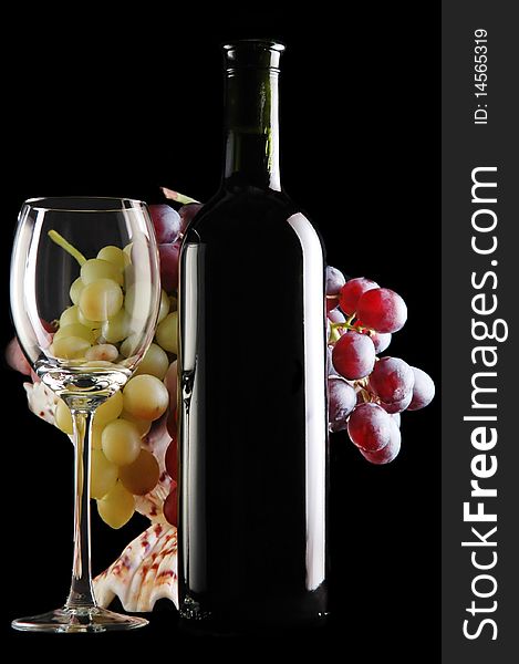 Different grapes and glass of red wine on black
