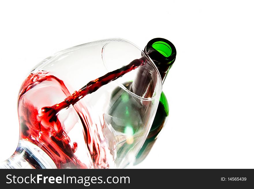 Red wine pouring down from a wine bottle against white background