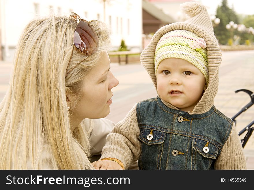 Mum explains something to the child which costs nearby and listens. Mum explains something to the child which costs nearby and listens