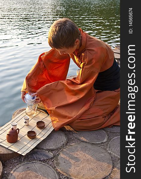 Tea ceremony master serving tea near the water