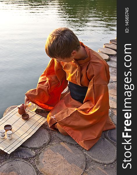 Tea ceremony master serving tea near the water