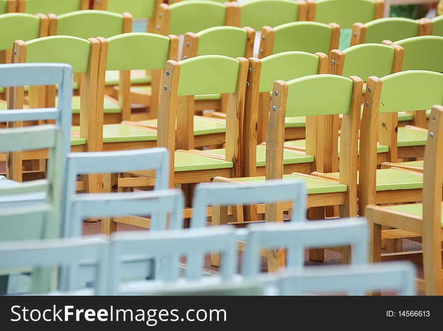 Pciture of wooden green and blue chairs put in straight rows in a kindergarten for a celebration. Pciture of wooden green and blue chairs put in straight rows in a kindergarten for a celebration