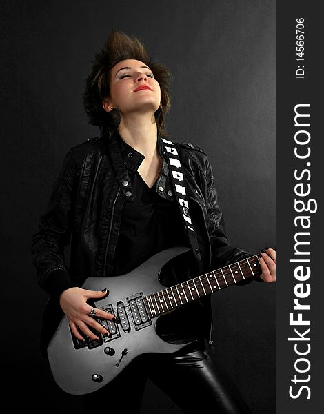 Rock girl in leather outfit with electric guitar