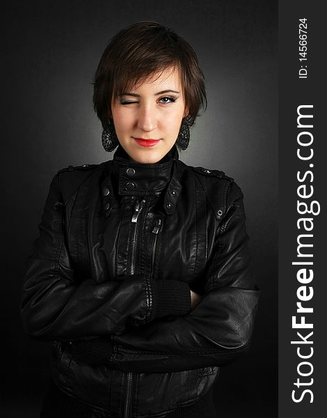 Rock girl in leather outfit smiling on black background