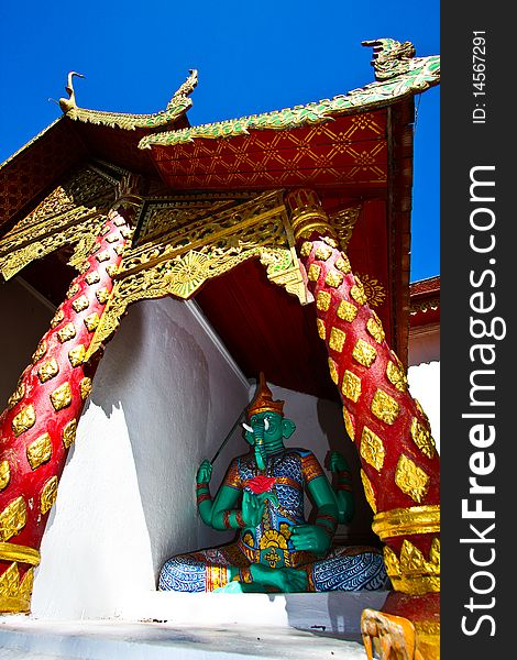 Green devil protector sitting at the front gate of Doi Suthep temple, Thailand