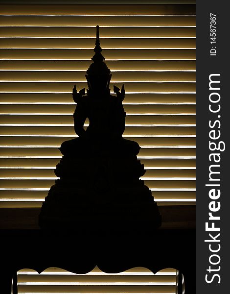 Silhouette of buddha at stand in the front of window light