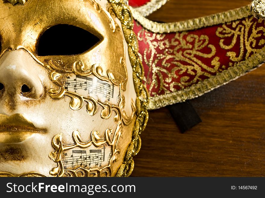 Photo of a venice carneval mask putted on a wood table. Photo of a venice carneval mask putted on a wood table