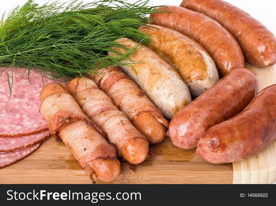 Grilled sausages on wooden plate