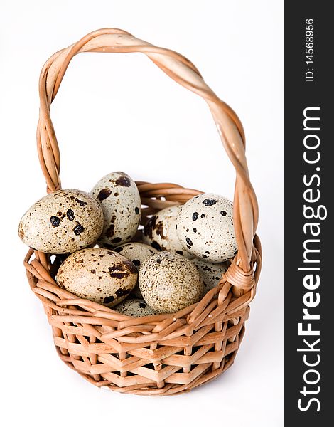 Quail eggs in basket isolated on a white background