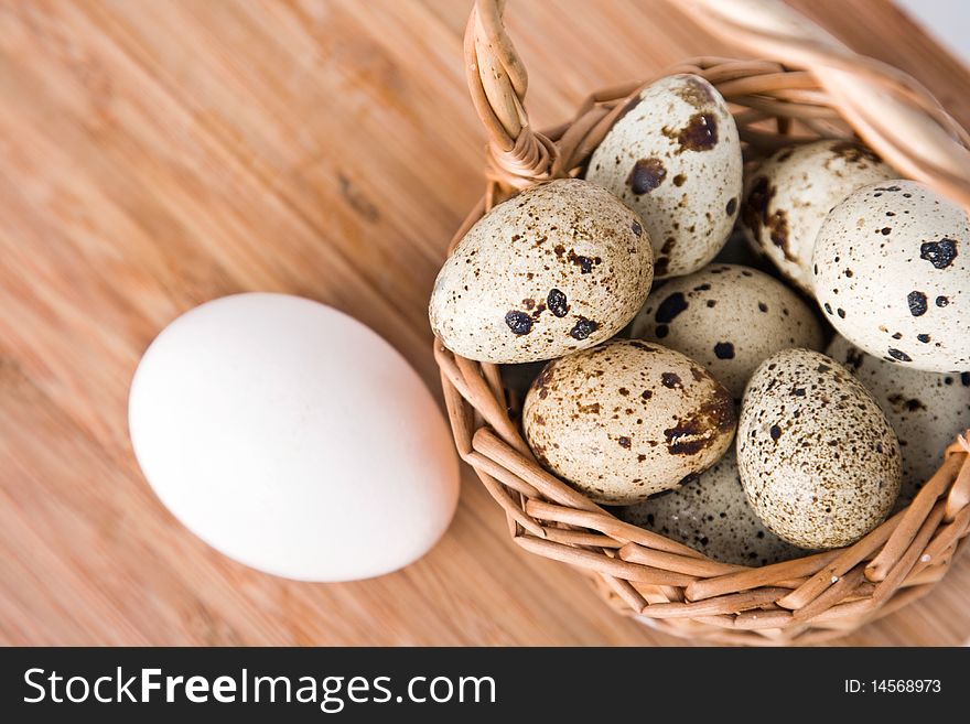 Eggs in basket on a wood background, small focus