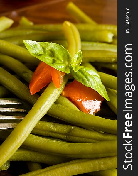 Photo of french beans on a glass platet putted on a wood table