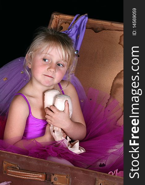 Little blond ballerina wearing a purple tutu