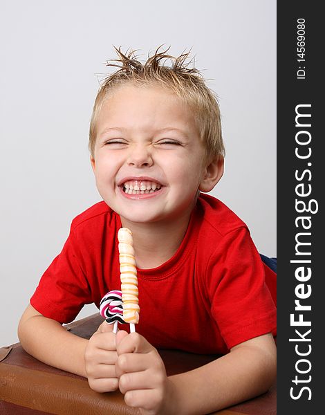 Young boy wearing a red shirt eating candy
