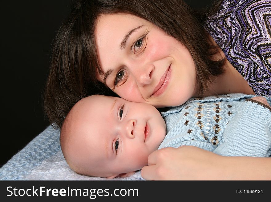 Beautiful brunette mother with her baby boy dressed in blue. Beautiful brunette mother with her baby boy dressed in blue