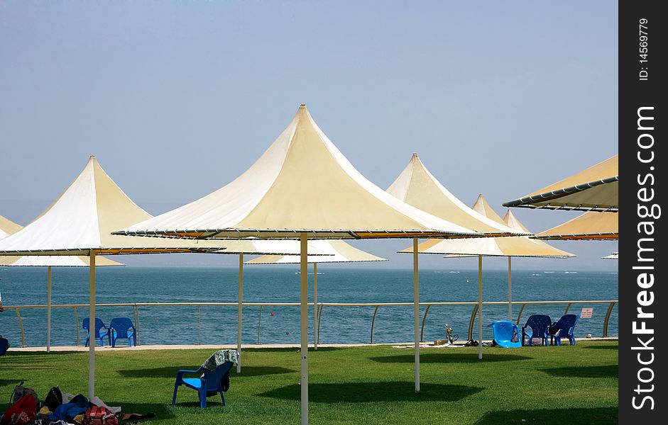 Beach view with colorful sunshade and green grass