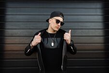 Serious Young Hipster Man In A Black Baseball Cap In Stylish Dark Sunglasses In A Vintage Leather Jacket Royalty Free Stock Photography