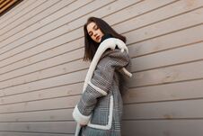 Young Pretty Attractive Woman In A Luxurious Checkered Jacket  With White Fur In Retro Style Is Posing On The Street Royalty Free Stock Photos