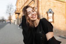 Young Joyful Beautiful Woman With A Wonderful Smile In A Stylish T-shirt In A Elegant Coat Posing On A Sunny Day In The City Royalty Free Stock Photos
