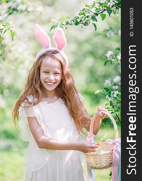 Adorable Little Girl In Blooming Apple Garden On Beautiful Spring Day