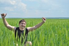 A Man Sits In A Field Of Green Wheat Stock Photography