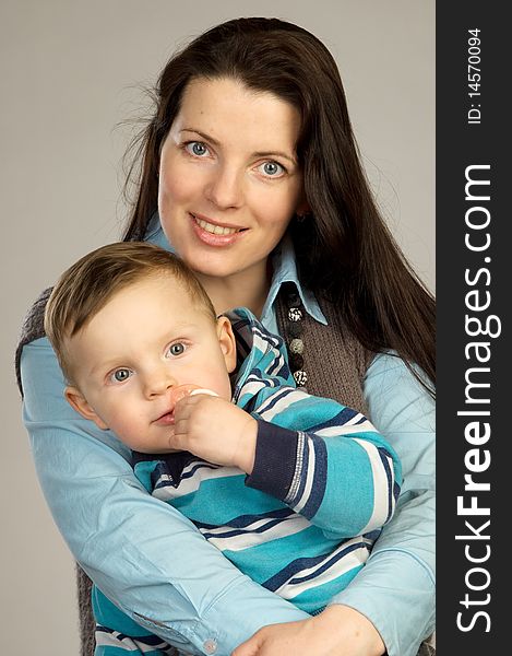 Smiling mother with son, studio shot, gray background