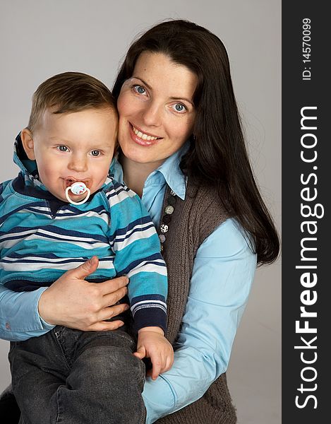 Smiling mother with son, studio shot, gray background. Smiling mother with son, studio shot, gray background