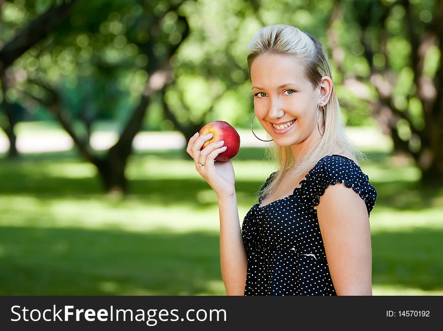 Girl with apple in park, outdoors