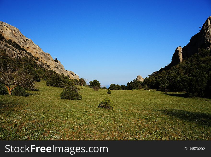 Mountain landscape east of crimea. The mountains and rocks, covered with juniper and pine. Blue sky. Mountain landscape east of crimea. The mountains and rocks, covered with juniper and pine. Blue sky