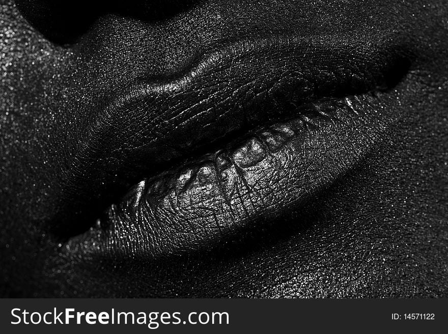 The lips of a young girl covered with black paint