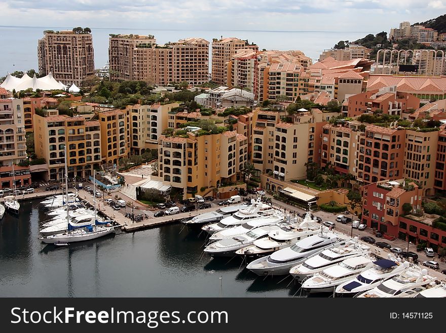 Mooring with yachts near many-storeyed buildings behind which the sea is visible. Mooring with yachts near many-storeyed buildings behind which the sea is visible