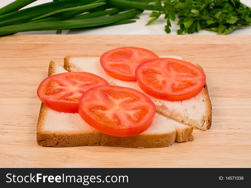 Cooking sandwich. Bread and tomato on a cutting board. Cooking sandwich. Bread and tomato on a cutting board
