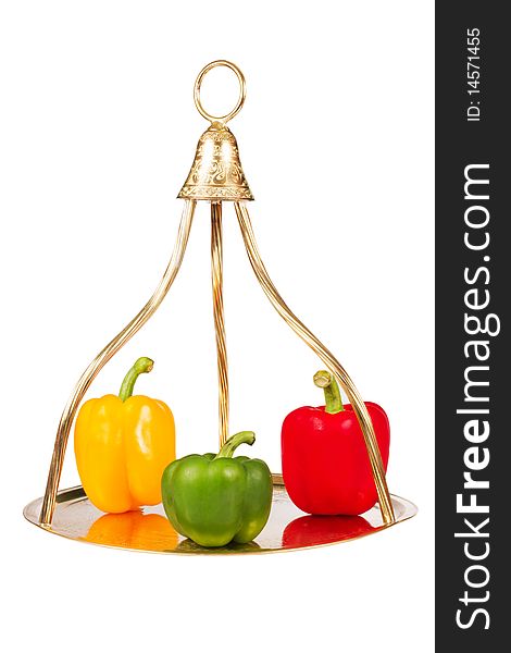 Three colorful pepper on gold tray isolated in white