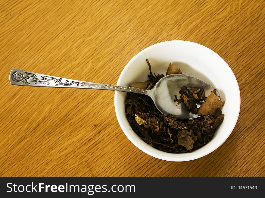 Spoon lying in a bowl in which tobacco lies. Spoon lying in a bowl in which tobacco lies