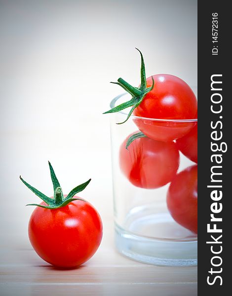 Whole cherry tomatoes in glass, on a bamboo mat. Whole cherry tomatoes in glass, on a bamboo mat.