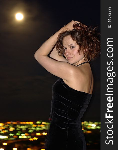 Female in a little black dress under full moon. Female in a little black dress under full moon