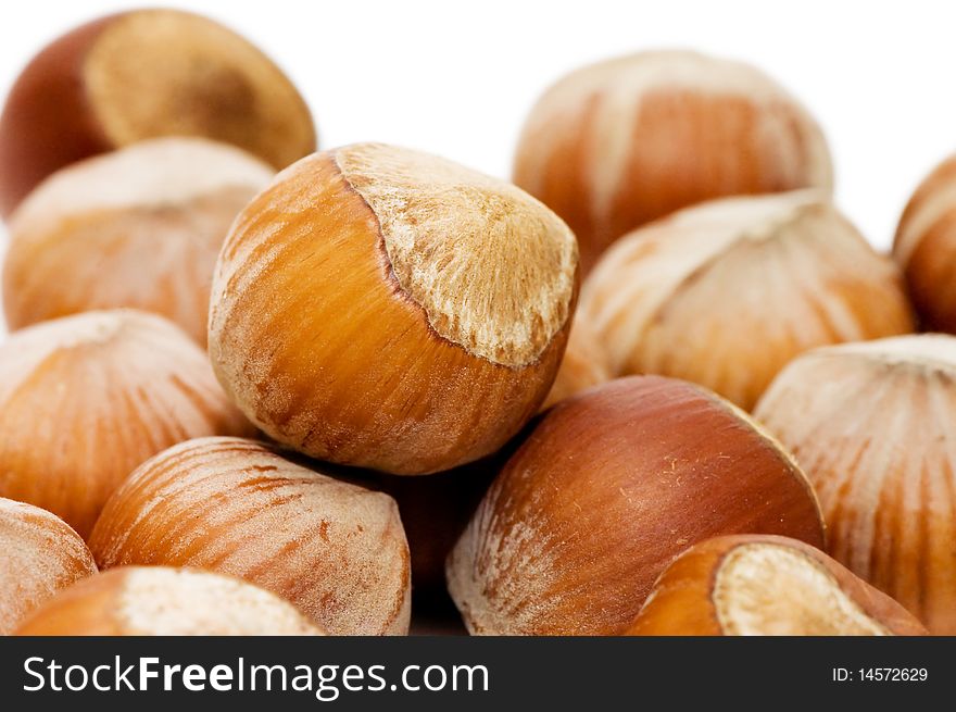 Heap of hazelnuts on white background close up