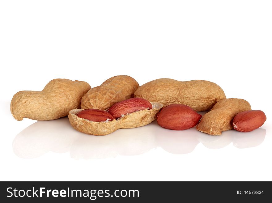 Peanuts in shells and cracked open, isolated over white background with reflection. Also known as monkey nuts.