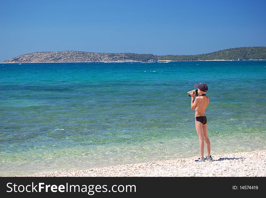 A small boy is making a video of croatian adriatic sea. A small boy is making a video of croatian adriatic sea