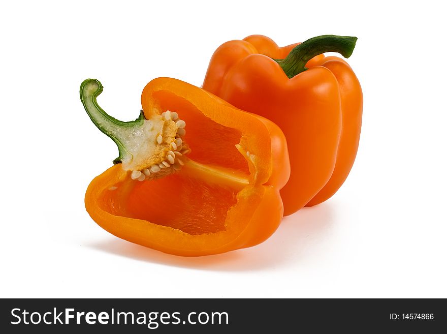 Two orange peppers (one full and another half cutted)  isolated on white. Two orange peppers (one full and another half cutted)  isolated on white
