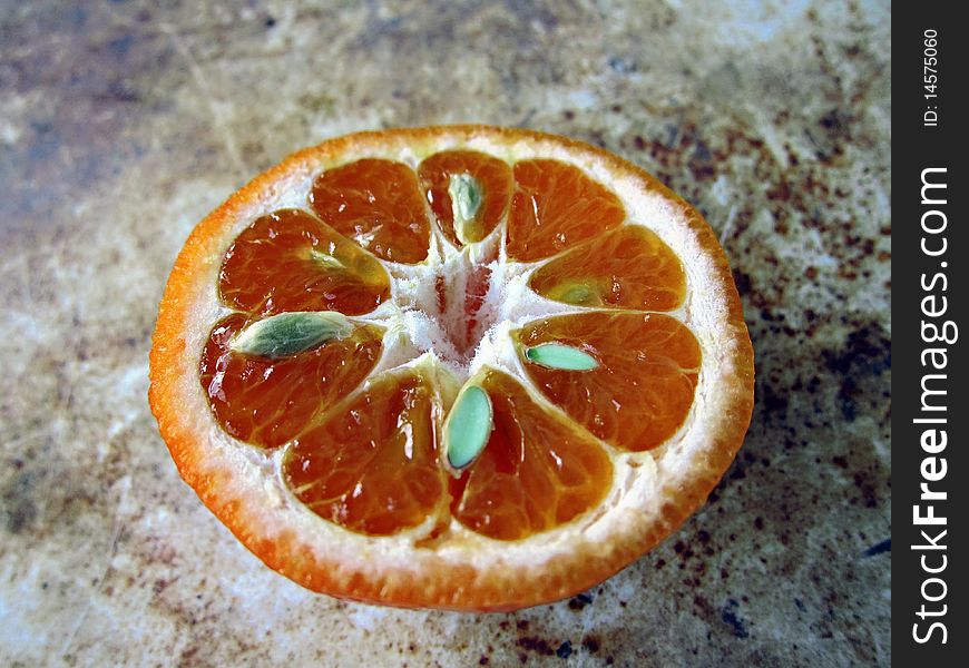 Half orange with seeds on a rough background