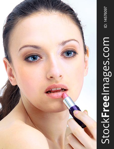 Portrait of beautiful woman applying lipstick