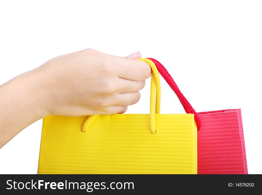 Hand holding a yellow and red shopping bag