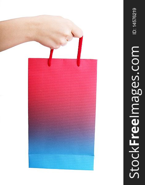 Hand holding a shopping bag over white background
