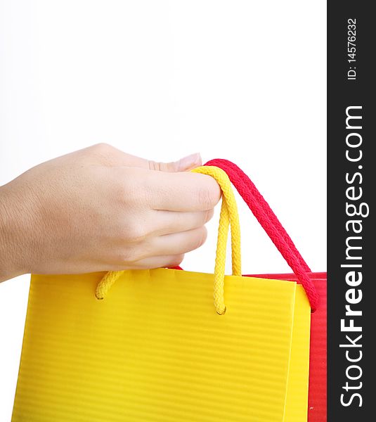 Hand holding a shopping bag over white background