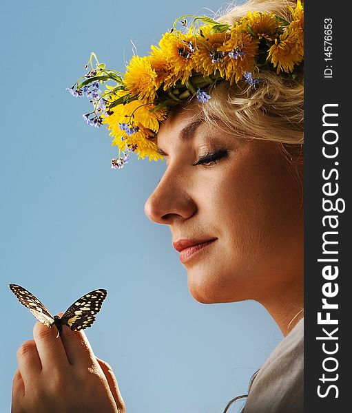 Lovely woman with a butterfly over blue sky